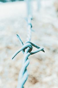 Close-up of rope tied on metal chain on field