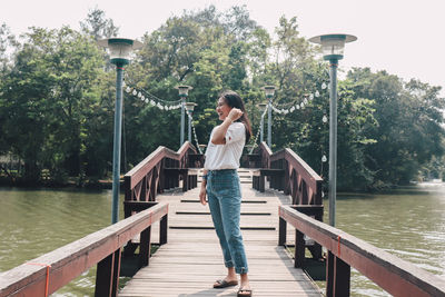 Woman standing on pier over lake