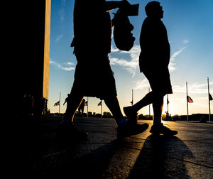 Silhouette of woman standing against sky at sunset