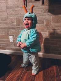 Full length of boy standing against wall