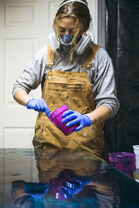 Female resin artist mixing resin tint for new artwork