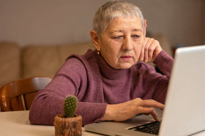 Portrait of senior man using laptop at home