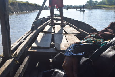 Low section of people sitting on boat sailing in river