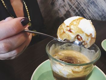 Close-up of hand holding ice cream on table