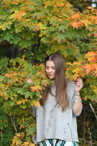 Young woman standing by plants