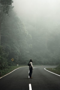 Side view of man standing on road