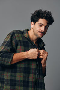 Portrait of young man standing against white background