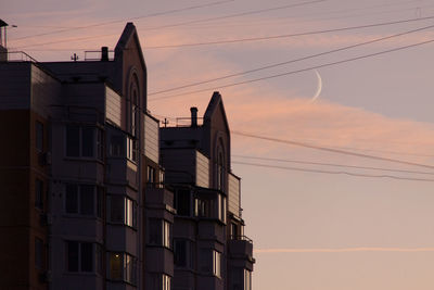 Low angle view of silhouette buildings against sky at sunset