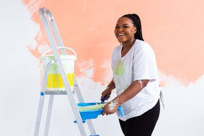 Portrait of woman working against wall