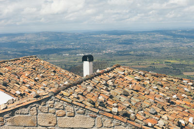 Houses by landscape against sky