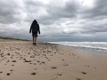 Rear view of woman walking on beach