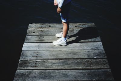 Low section of man standing on pier