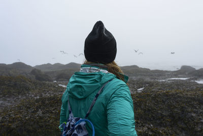 Rear view of hiker looking at view while standing at olympic coast