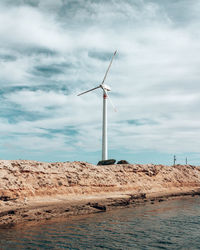 Wind turbines on land against sky