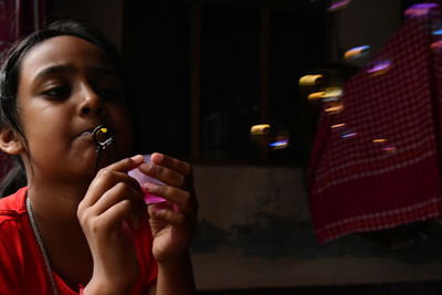 Girl blowing bubbles at home