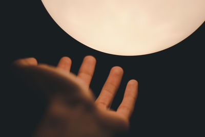 Close-up of hand holding illuminated lamp