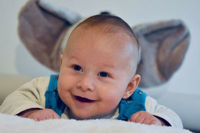 Smiling cute baby looking away while lying on bed at home