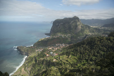 Scenic view of sea and mountains against sky