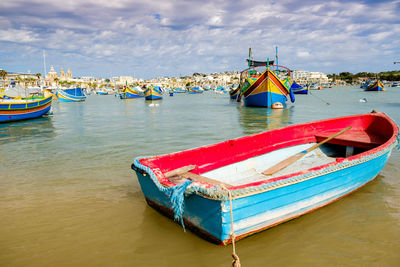 Boat moored in sea against sky