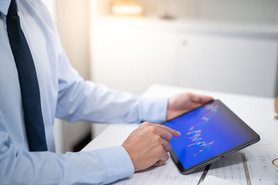 Midsection of doctor using laptop