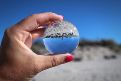 Close-up of hand holding blue sky