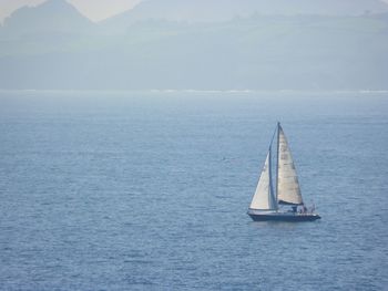 Sailboat sailing on sea against sky