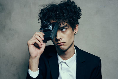 Portrait of young man holding camera