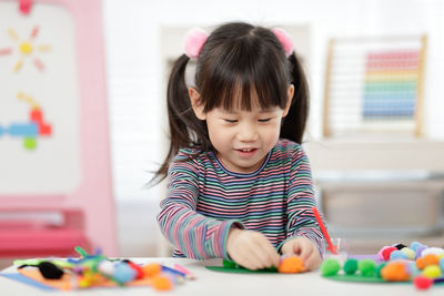 Cute boy playing with toy on table