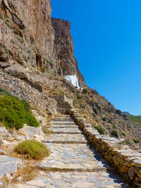 Steps leading towards mountain against clear blue sky