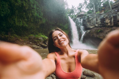 Young woman against waterfall
