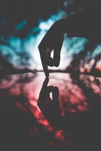 Low angle view of silhouette man standing against sky during sunset