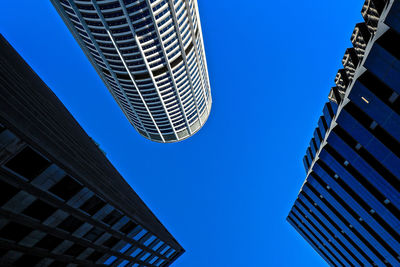 Low angle view of modern buildings against clear blue sky