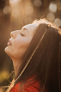 Outdoor portrait of beautiful smiling woman in sunlight. smiling relaxing woman with boho hair