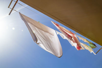 Low angle view of flag hanging against blue sky