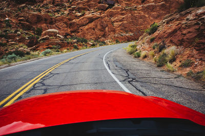 Cropped image of red car on road