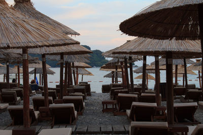 Chairs and parasols on beach against sky