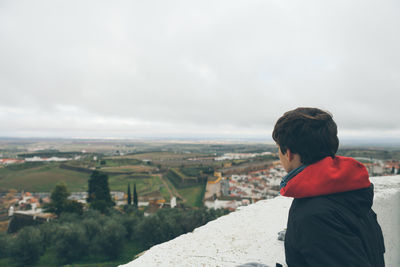 Woman looking at mountain landscape against cloudy sky