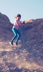 Full length of woman with arms raised against sky