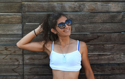 Portrait of young woman wearing sunglasses standing outdoors