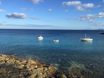 Boats in sea against sky