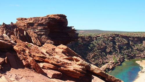 Low angle view of rocky mountain against blue sky