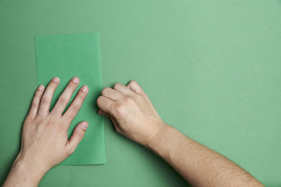 Close-up of hands against blue background