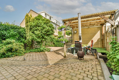 Footpath amidst houses against sky