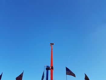 Low angle view of carousel  against clear blue sky