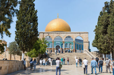 Group of people outside temple against sky