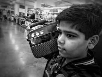 Close-up portrait of boy holding camera