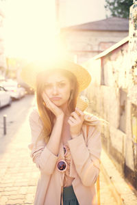 Portrait of young woman wearing hat standing outdoors