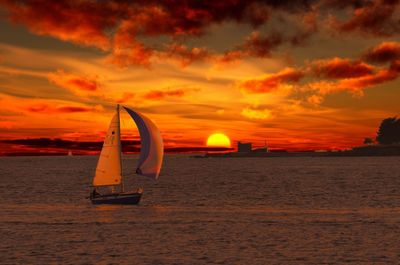 Sailboat on beach against sky during sunset