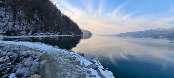 Scenic view of lake against sky during winter