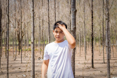 Portrait of young man standing in forest